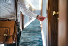 1765865810 Man entering hotel room with key card close up