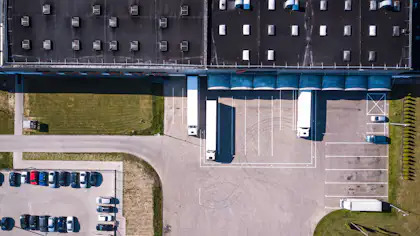Industrial logistics large lorries warehouse shed shutterstock 1023449962